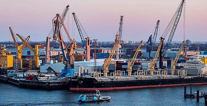 Port cranes and break bulk cargo operations at sunset